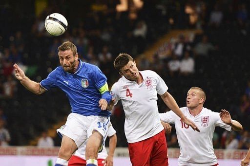 Italy's midfielder Daniele De Rossi (L) scores as England's midfielder Michael Carrick (C) tries to head the ball